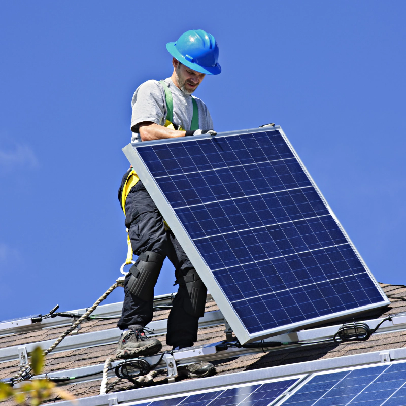 a person carefully installing a solar panel